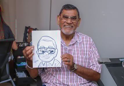 Attendee posing next to their caricature art