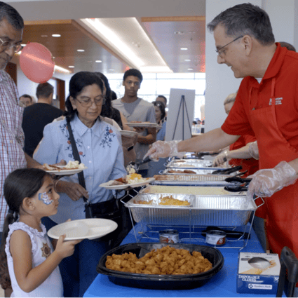 MCCU's Chief Financial Officer Keith Hrnyak serving Attendees Rudy's BBQ