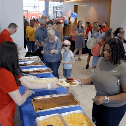 MCCU's Chief Marketing Officer serving attendees Rudys BBQ